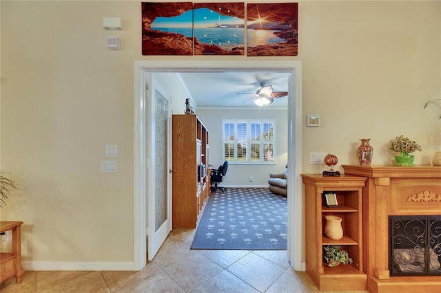 foyer entrance with light tile patterned floors, ornamental molding, and ceiling fan