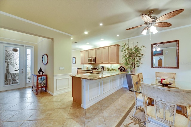 kitchen featuring appliances with stainless steel finishes, light brown cabinetry, ornamental molding, light tile patterned floors, and kitchen peninsula