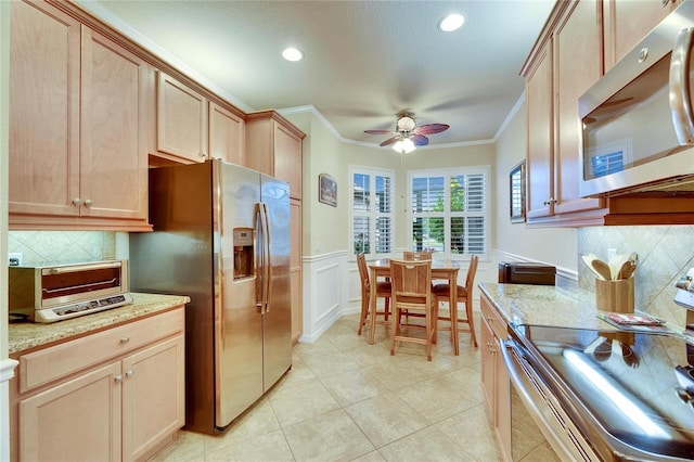 kitchen with light stone counters, light brown cabinetry, ornamental molding, and stainless steel appliances