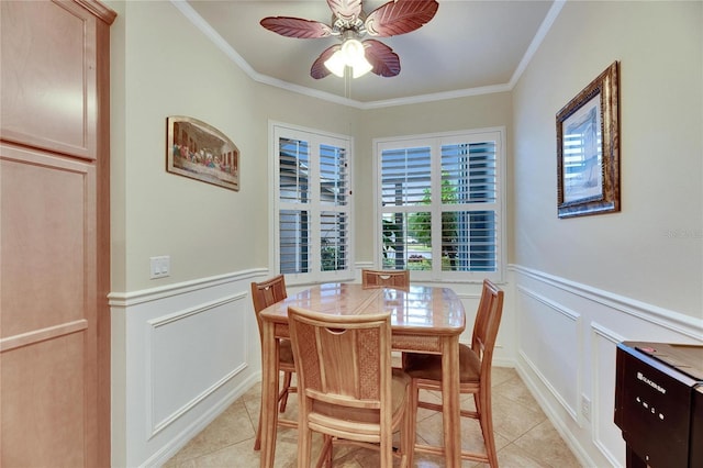 tiled dining room featuring crown molding and ceiling fan