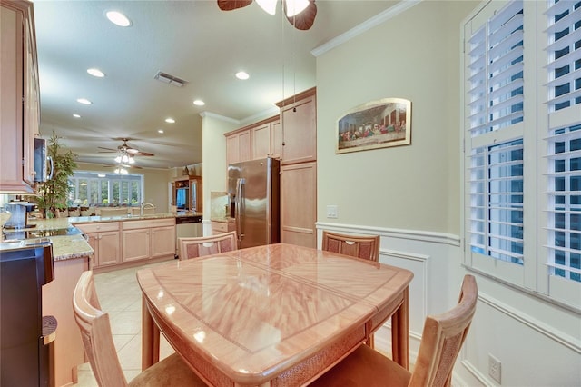 dining area featuring light tile patterned flooring, ceiling fan, ornamental molding, and sink