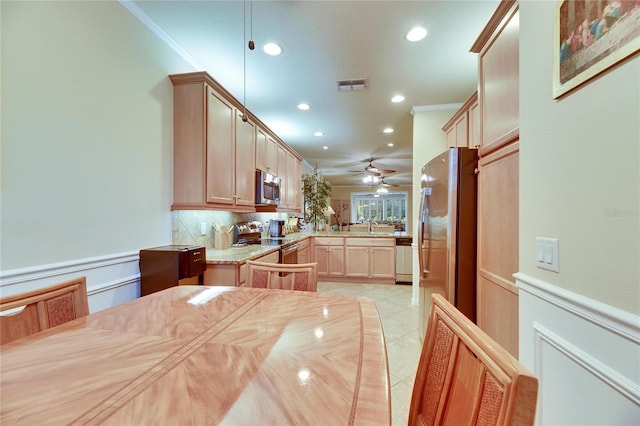 kitchen featuring crown molding, appliances with stainless steel finishes, light tile patterned floors, and light brown cabinets