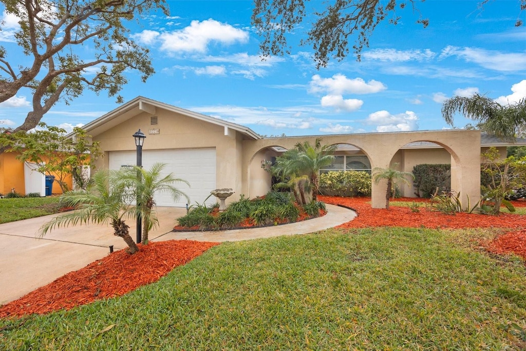 single story home with a garage and a front lawn