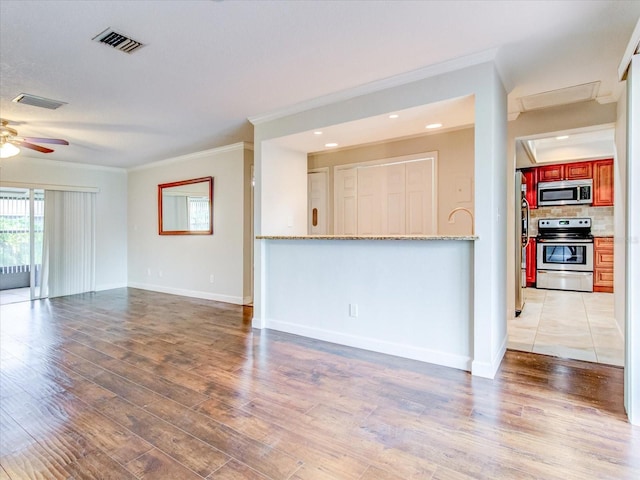 unfurnished living room with hardwood / wood-style flooring, ornamental molding, and ceiling fan