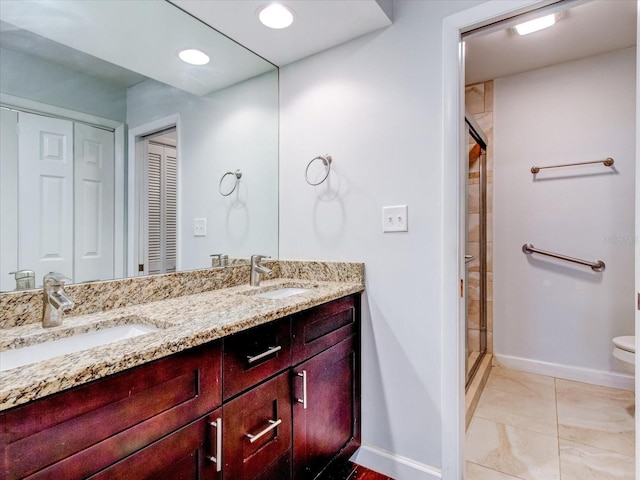 bathroom featuring vanity, toilet, and a shower with door