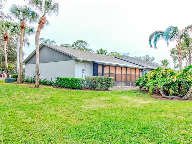 view of property exterior featuring a yard and a sunroom