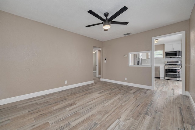 unfurnished living room featuring ceiling fan and light hardwood / wood-style flooring