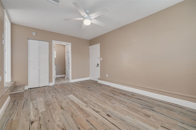 unfurnished bedroom featuring a closet, ceiling fan, and light wood-type flooring