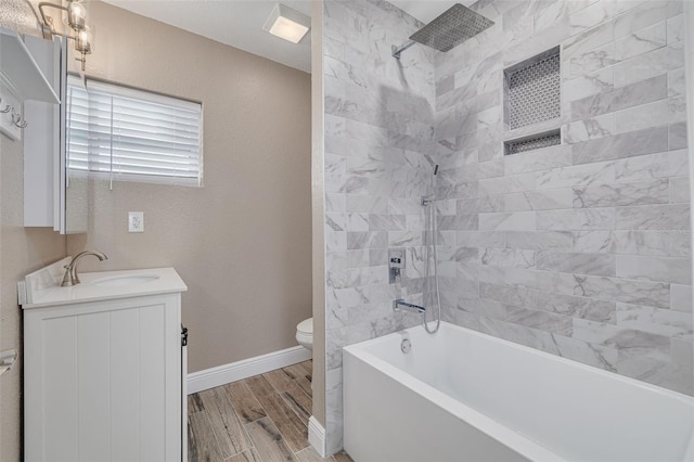 full bathroom with vanity, tiled shower / bath, and toilet