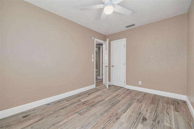 spare room featuring ceiling fan and light hardwood / wood-style floors