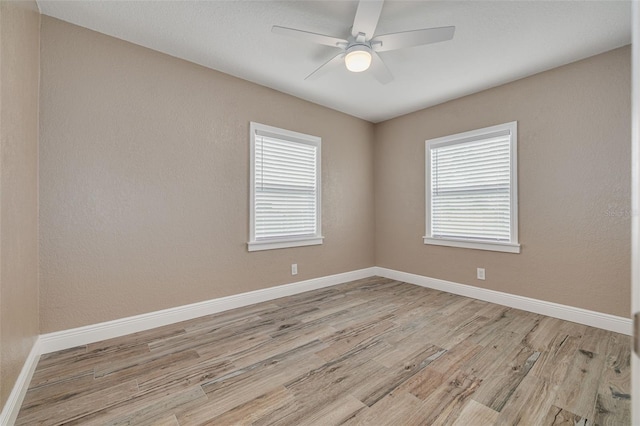 spare room featuring ceiling fan, a healthy amount of sunlight, and light hardwood / wood-style floors