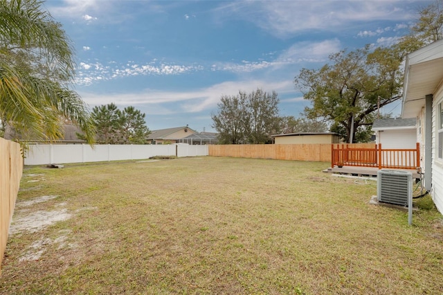 view of yard with central AC and a deck