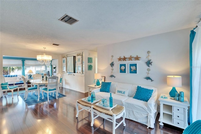 2589 Redwood Cir, Clearwater, FL 33763 - living room featuring a textured ceiling, a chandelier, wood finished floors, and baseboards