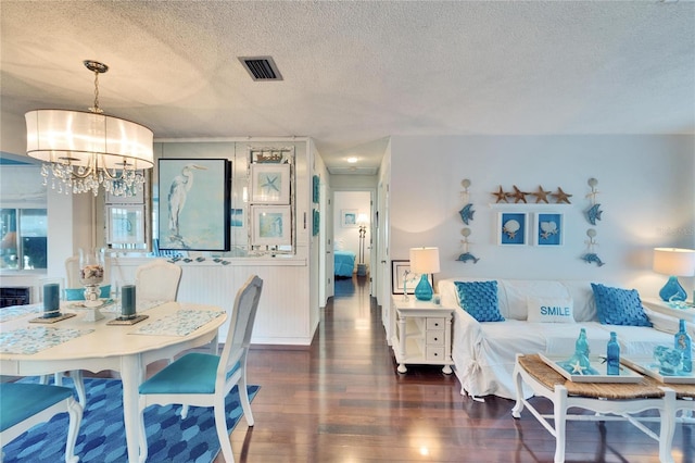 2589 Redwood Cir, Clearwater, FL 33763 - dining space featuring wood finished floors, a textured ceiling, a chandelier, and a wainscoted wall
