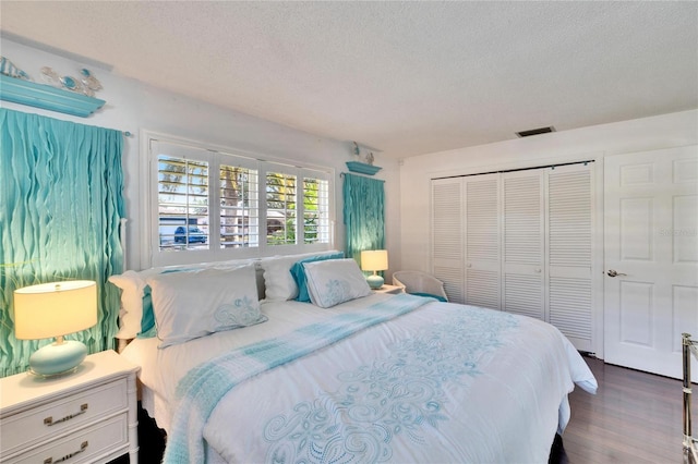 2589 Redwood Cir, Clearwater, FL 33763 - bedroom with a textured ceiling, a closet, and dark wood-style floors