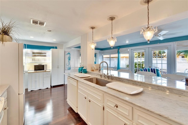 2589 Redwood Cir, Clearwater, FL 33763 - kitchen with white appliances, a sink, dark wood-type flooring, french doors, and decorative light fixtures