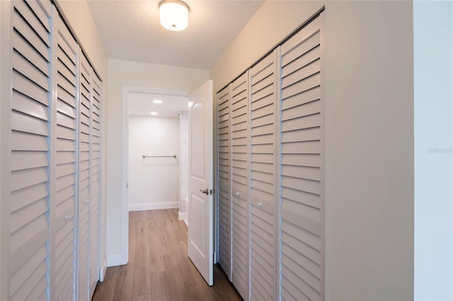 hallway featuring hardwood / wood-style flooring and a textured ceiling