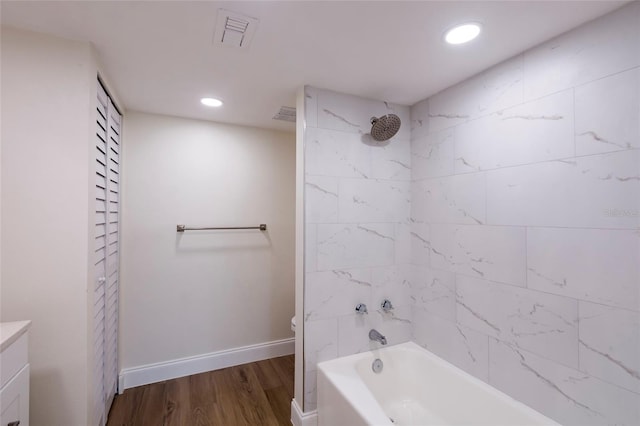 full bathroom featuring tiled shower / bath combo, wood-type flooring, vanity, and toilet