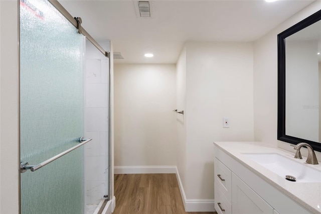 bathroom with vanity, wood-type flooring, and walk in shower