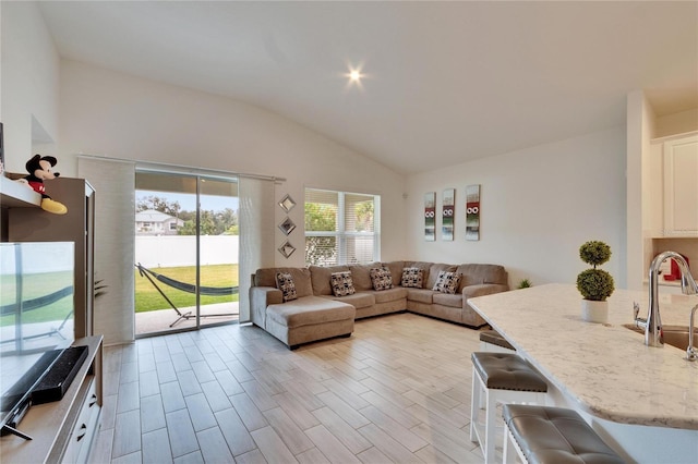 living room with sink and vaulted ceiling