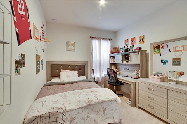 bedroom featuring light colored carpet and built in desk