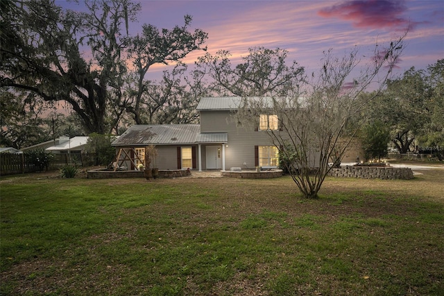 back house at dusk featuring a yard