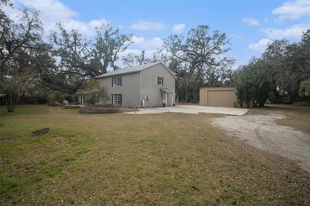 view of property exterior featuring a garage, an outbuilding, and a lawn