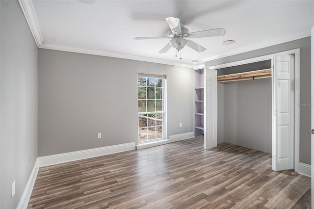 unfurnished bedroom featuring a textured ceiling, ornamental molding, a closet, and ceiling fan