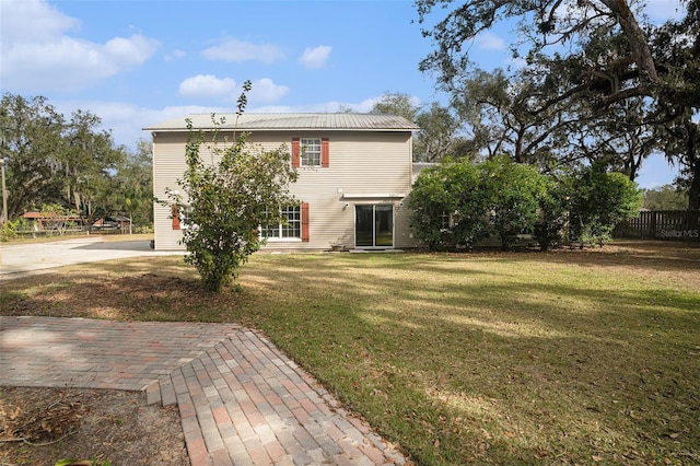 rear view of property featuring a lawn