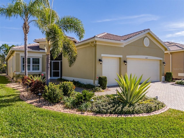 mediterranean / spanish-style house featuring a garage and a front yard