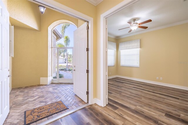 entryway with ceiling fan, a healthy amount of sunlight, and ornamental molding