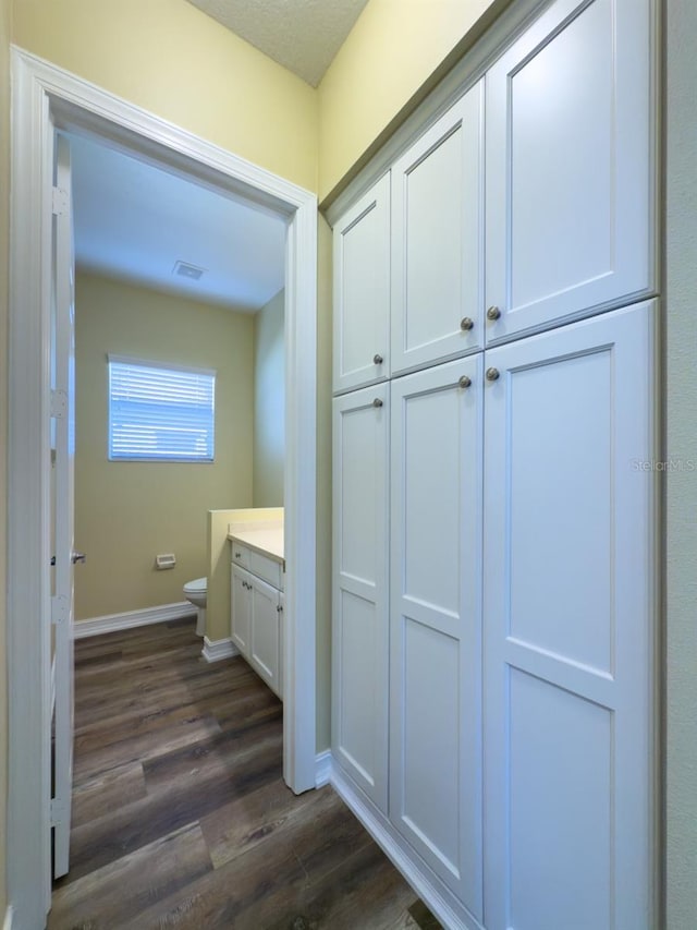 bathroom featuring hardwood / wood-style flooring, vanity, and toilet