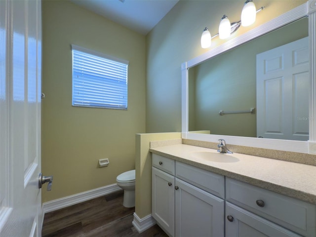 bathroom with vanity, wood-type flooring, and toilet