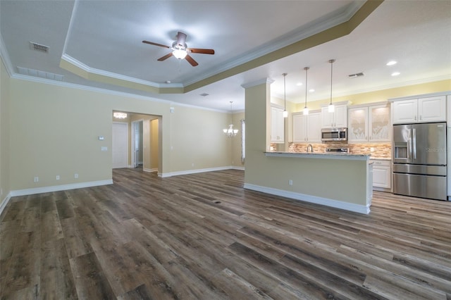 kitchen featuring backsplash, stainless steel appliances, a raised ceiling, and white cabinets