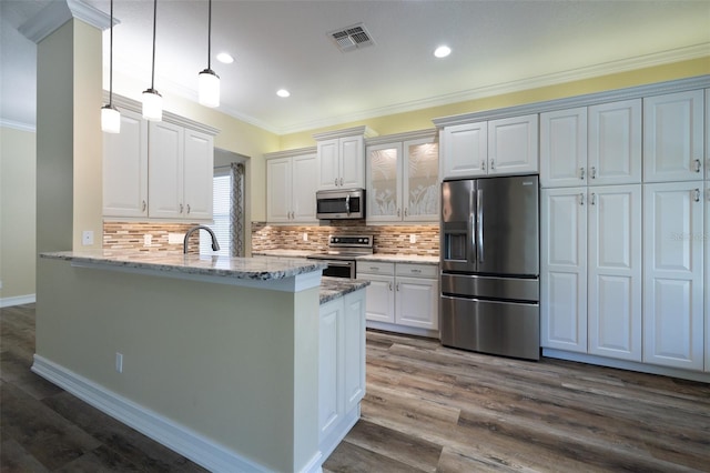 kitchen with decorative light fixtures, stainless steel appliances, kitchen peninsula, and white cabinets