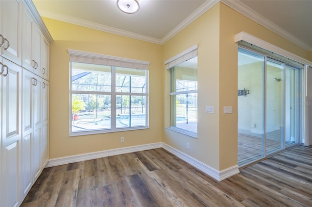 doorway to outside featuring crown molding, wood-type flooring, and plenty of natural light