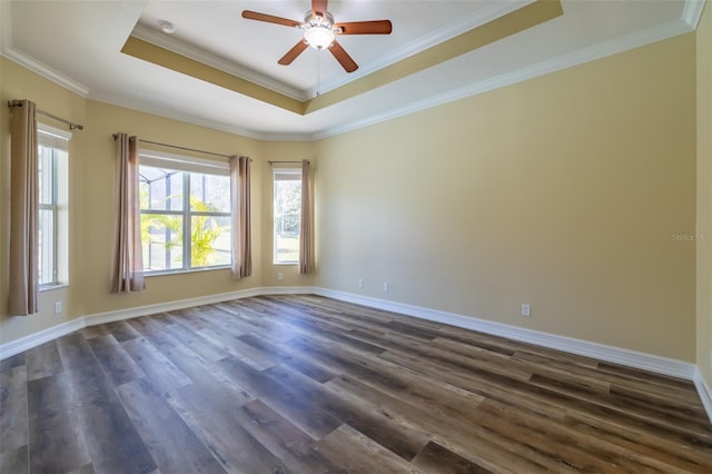 unfurnished room with ornamental molding, dark wood-type flooring, ceiling fan, and a tray ceiling