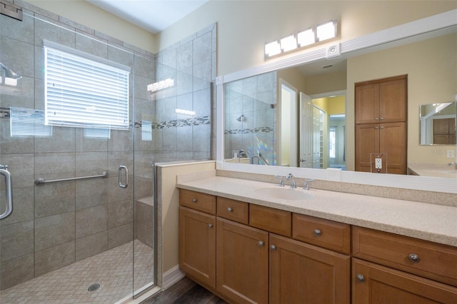 bathroom featuring wood-type flooring, a shower with shower door, and vanity