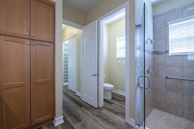 bathroom featuring hardwood / wood-style floors, an enclosed shower, and toilet