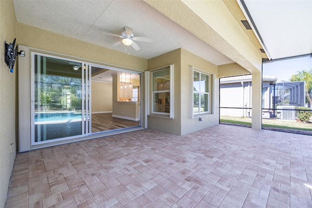 view of patio / terrace featuring ceiling fan and glass enclosure