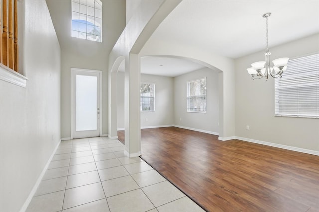 tiled entrance foyer with a chandelier