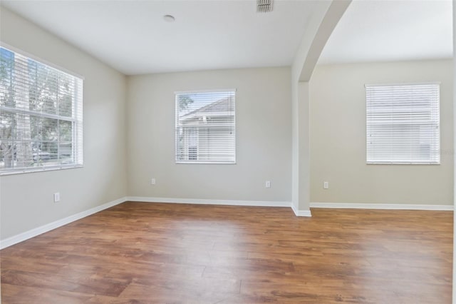 spare room with hardwood / wood-style flooring and plenty of natural light