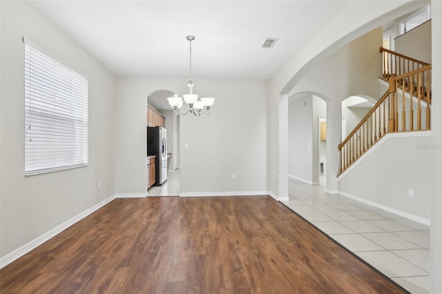 unfurnished dining area with an inviting chandelier and light tile patterned flooring