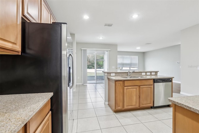 kitchen featuring sink, light tile patterned floors, light stone countertops, and appliances with stainless steel finishes