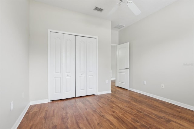 unfurnished bedroom with dark hardwood / wood-style flooring, a closet, and ceiling fan