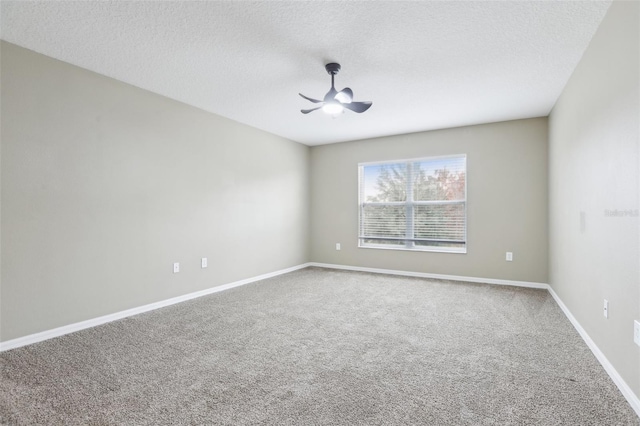 carpeted empty room featuring ceiling fan and a textured ceiling