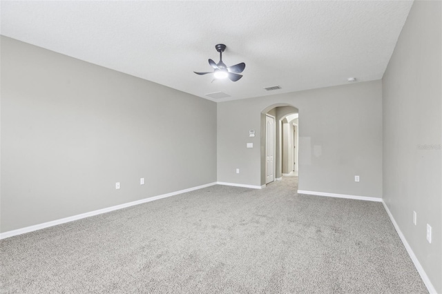 empty room with ceiling fan, carpet floors, and a textured ceiling