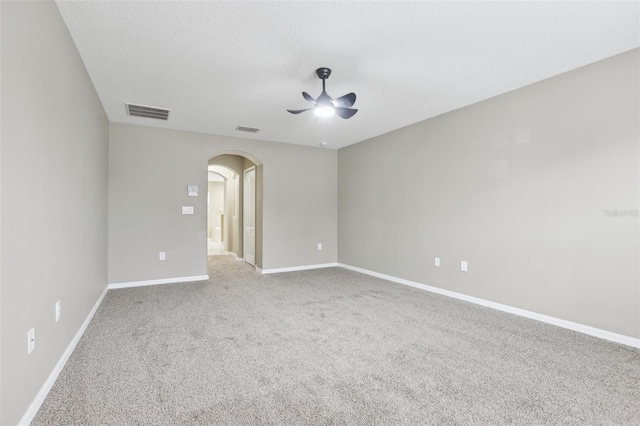 carpeted empty room featuring ceiling fan and a textured ceiling