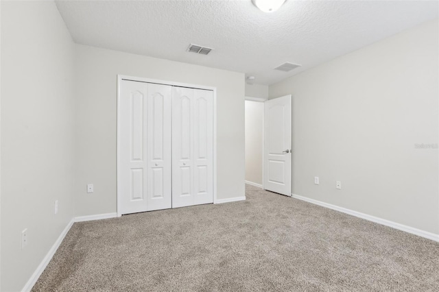 unfurnished bedroom featuring carpet floors, a closet, and a textured ceiling