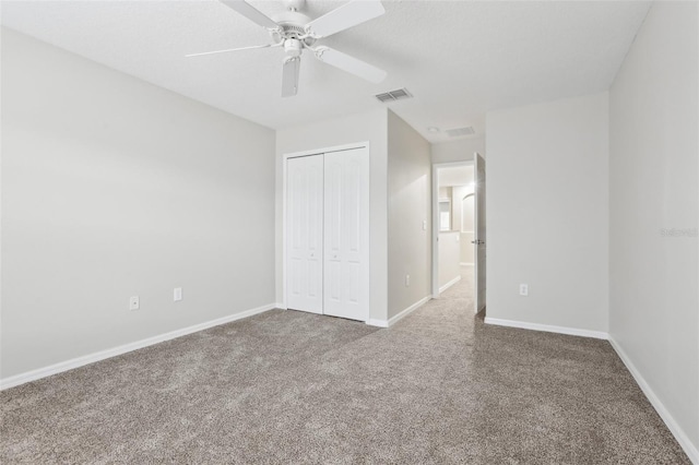 unfurnished bedroom with carpet floors, ceiling fan, and a closet